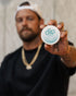 Ryan Sheckler holding a 'diip' branded 8 tropical nicotine-free dip pouch can against a neutral background