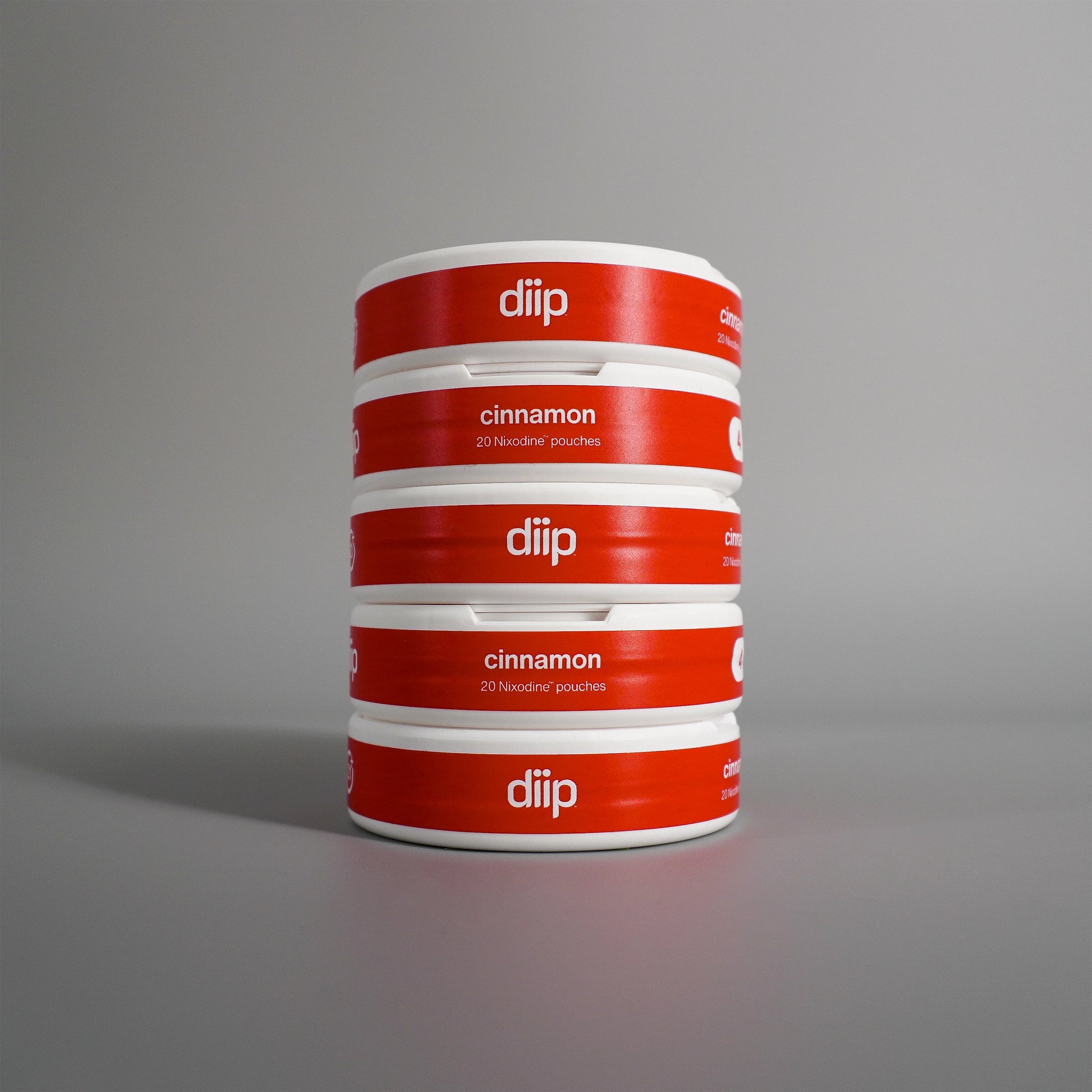 diip cinnamon 4 nicotine-free dip pouch cans standing upright in front of a white background